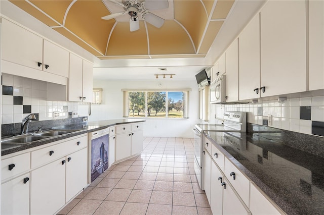 kitchen with white appliances, light tile patterned floors, decorative backsplash, and a sink