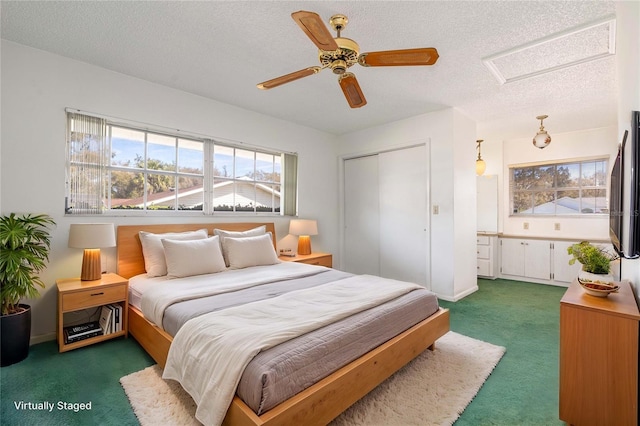 bedroom featuring attic access, baseboards, carpet, a textured ceiling, and a closet