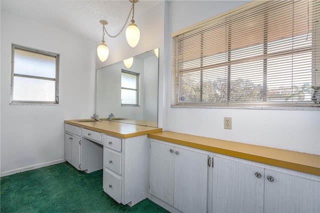 bathroom featuring baseboards, a textured ceiling, and vanity