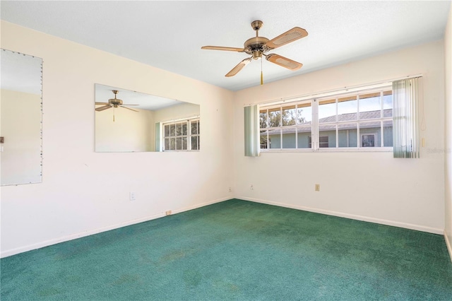 carpeted spare room with ceiling fan and baseboards