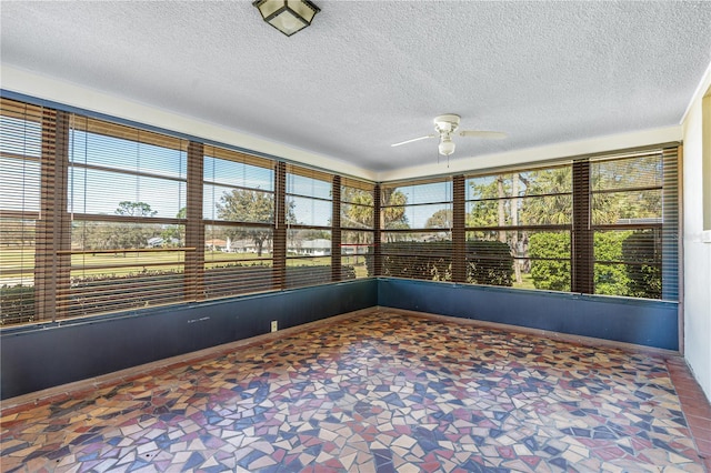 unfurnished sunroom with ceiling fan