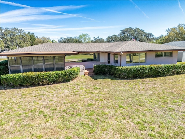 ranch-style home with a sunroom and a front lawn