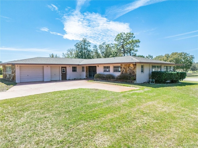 ranch-style home featuring driveway, an attached garage, and a front yard