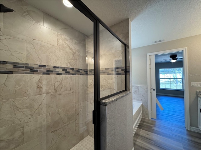 full bathroom with a stall shower, visible vents, wood finished floors, a textured ceiling, and a bath