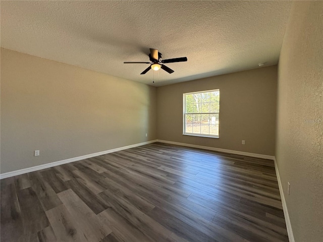 unfurnished room featuring dark wood-style flooring, a textured wall, a ceiling fan, a textured ceiling, and baseboards