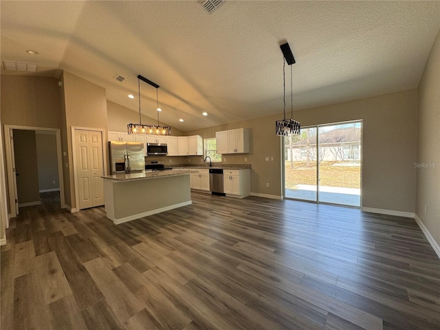 kitchen featuring white cabinets, dark wood-style floors, vaulted ceiling, and stainless steel appliances