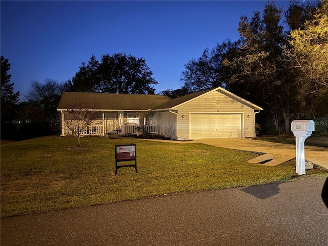 ranch-style home featuring a garage, concrete driveway, and a front yard