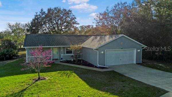 ranch-style home featuring a front yard, an attached garage, covered porch, and concrete driveway