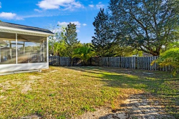 view of yard featuring a sunroom and a fenced backyard