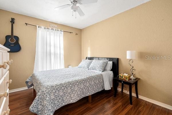 bedroom with dark wood-style floors, baseboards, and a ceiling fan