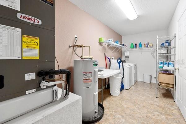 utility room with washer and dryer, electric water heater, and heating unit