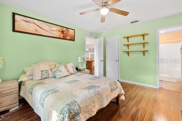 bedroom featuring a ceiling fan, baseboards, visible vents, and wood finished floors