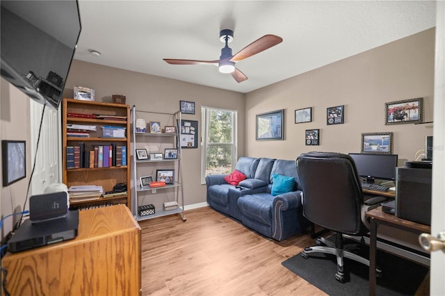 office featuring light wood-style flooring, baseboards, and a ceiling fan