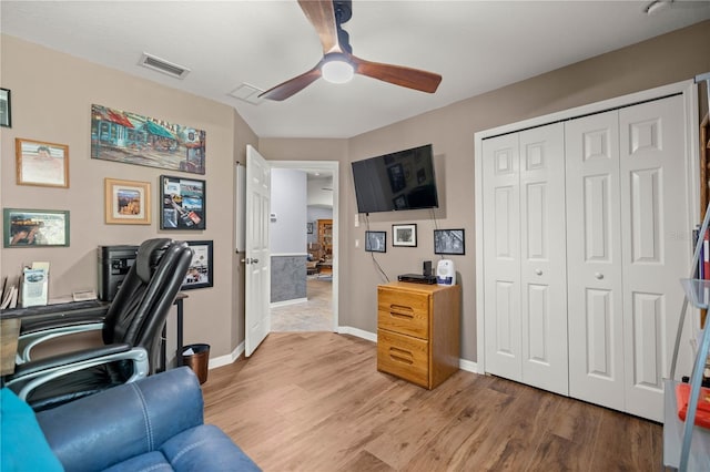 office area featuring light wood finished floors, ceiling fan, visible vents, and baseboards