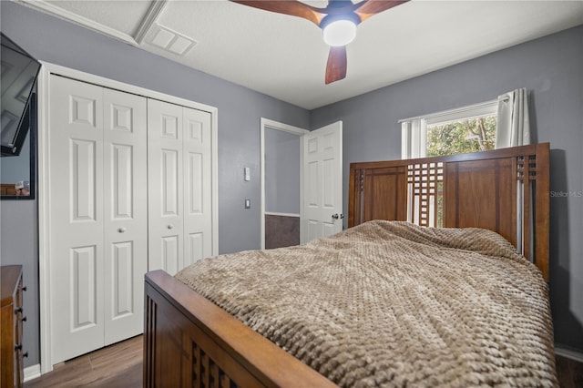 bedroom with dark wood-type flooring, a closet, and ceiling fan