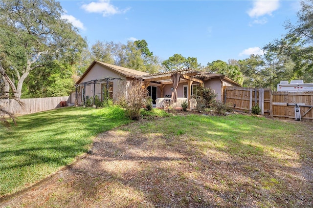 back of property featuring stucco siding, a fenced backyard, a pergola, and a yard