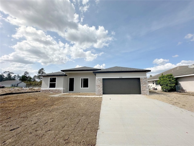 prairie-style house featuring driveway, stucco siding, an attached garage, and stone siding