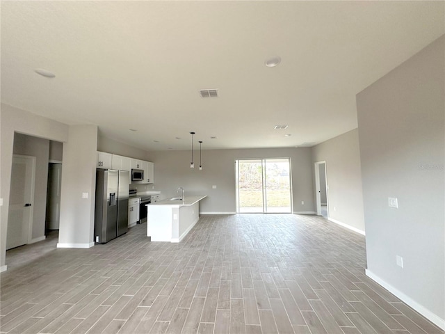 kitchen with light countertops, visible vents, stainless steel appliances, and open floor plan