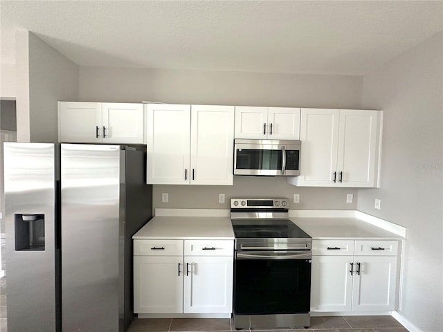 3085 SW 131st Place Rd, Ocala, FL 34473 - kitchen with stainless steel appliances, white cabinets, light countertops, and tile patterned floors