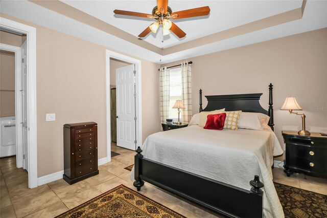 7234 SW 91st Ct, Ocala, FL 34481 - bedroom with a raised ceiling, light tile patterned floors, washer / dryer, baseboards, and a ceiling fan