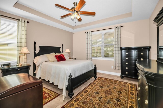 7234 SW 91st Ct, Ocala, FL 34481 - bedroom with a raised ceiling, light tile patterned floors, baseboards, and ceiling fan
