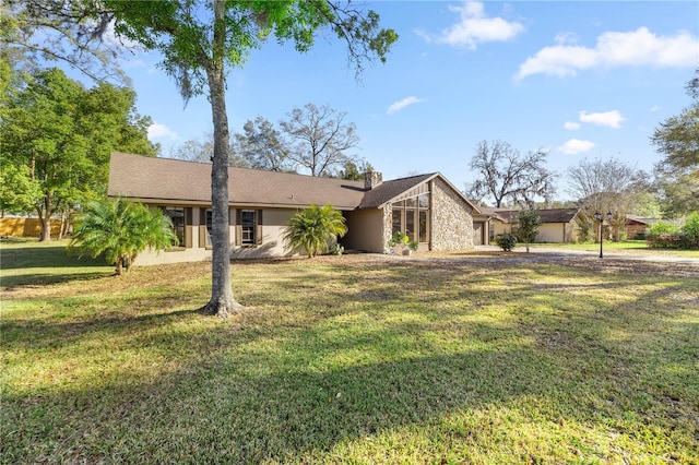 mid-century home with an attached garage, a front yard, and stucco siding