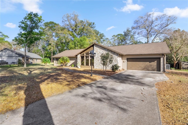 mid-century home with a garage, concrete driveway, and stucco siding