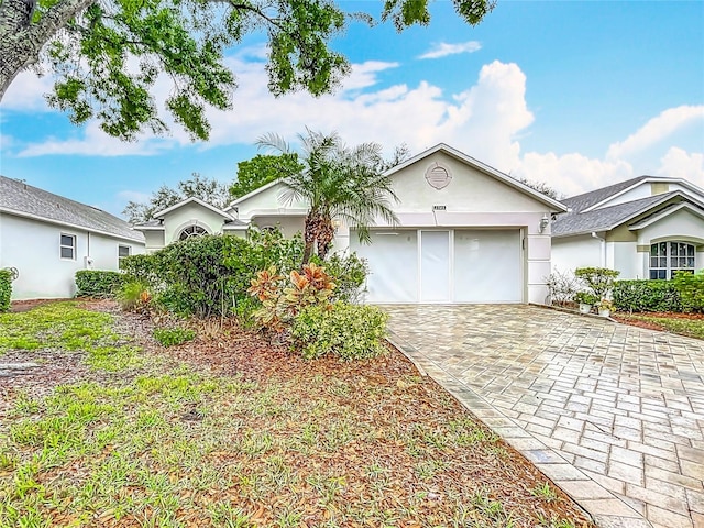 ranch-style house featuring decorative driveway and stucco siding