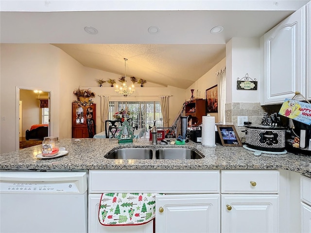 kitchen featuring lofted ceiling, a peninsula, white cabinetry, and dishwasher