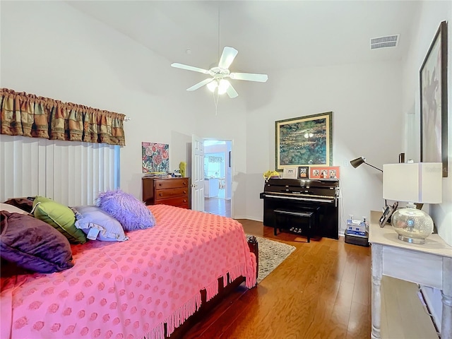 bedroom with high vaulted ceiling, wood finished floors, visible vents, and a ceiling fan