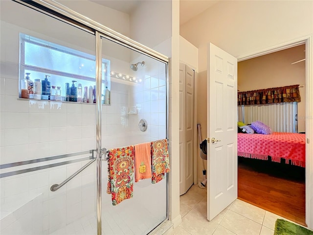 ensuite bathroom featuring a stall shower, tile patterned flooring, a closet, and ensuite bathroom