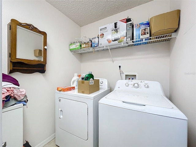 clothes washing area featuring a textured ceiling, laundry area, and washer and clothes dryer