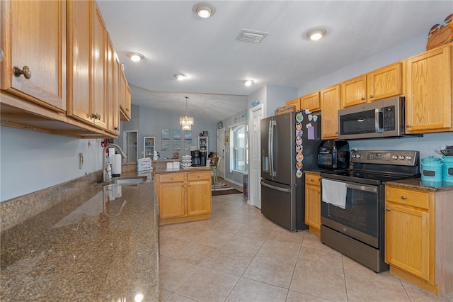 kitchen with visible vents, a sink, appliances with stainless steel finishes, a peninsula, and lofted ceiling