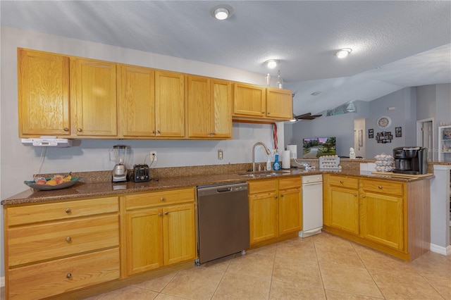 kitchen featuring light tile patterned floors, dishwasher, a peninsula, and a sink