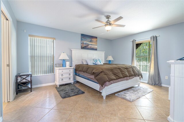 bedroom featuring light tile patterned floors, ceiling fan, and baseboards