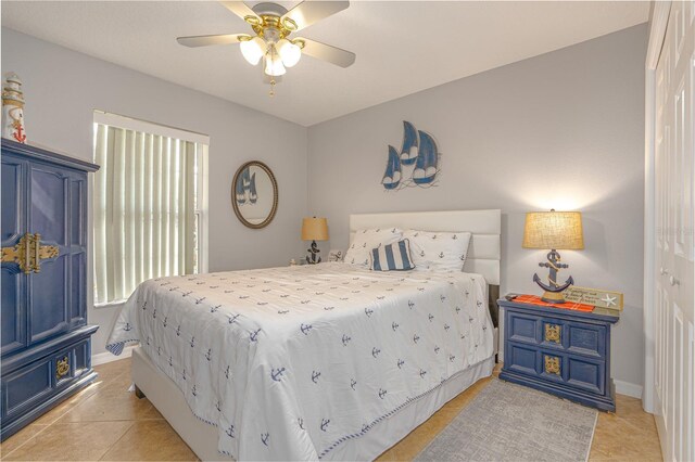 bedroom featuring baseboards, light tile patterned flooring, and a ceiling fan