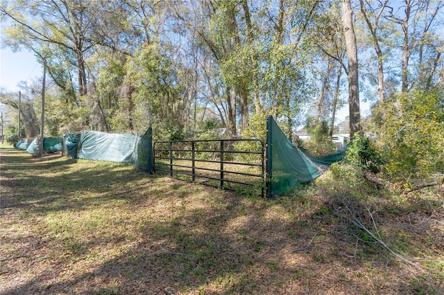 view of gate featuring a lawn and fence