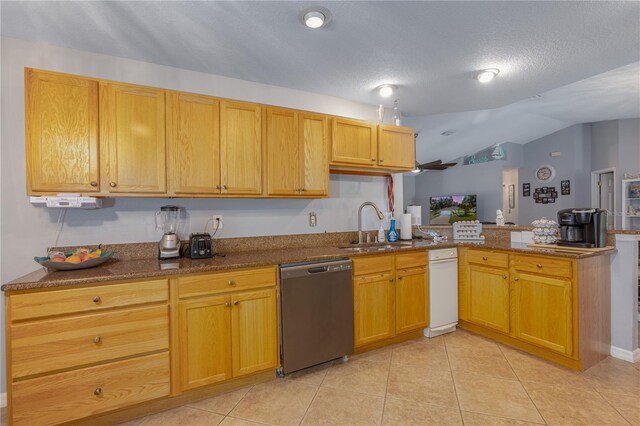 kitchen with light tile patterned floors, dishwasher, a peninsula, and a sink