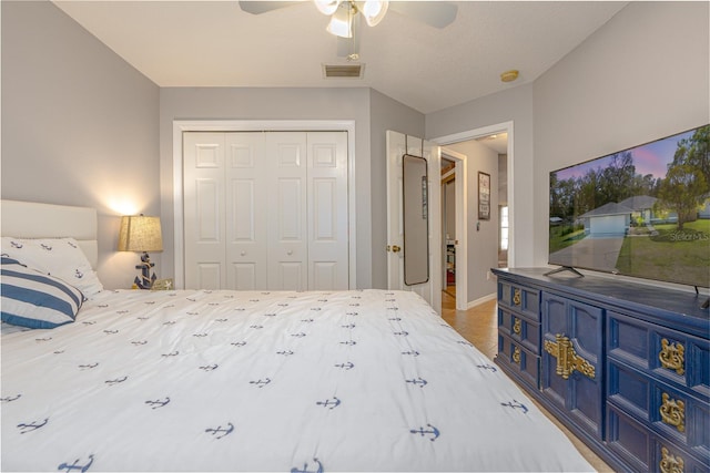 bedroom with light tile patterned floors, visible vents, a closet, and a ceiling fan