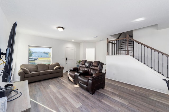 living area featuring stairway, baseboards, and wood finished floors