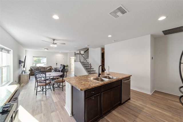 kitchen with an island with sink, dishwasher, visible vents, and a sink