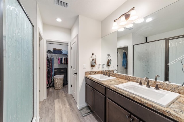 full bath featuring a spacious closet, a sink, visible vents, and a shower stall