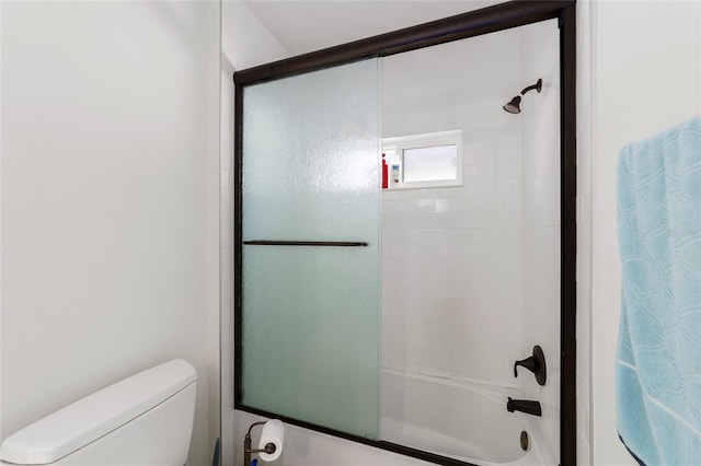 full bathroom with bath / shower combo with glass door and toilet