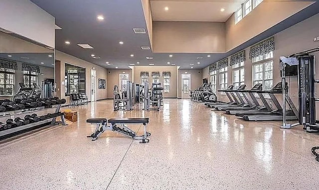 workout area featuring recessed lighting, visible vents, and a towering ceiling