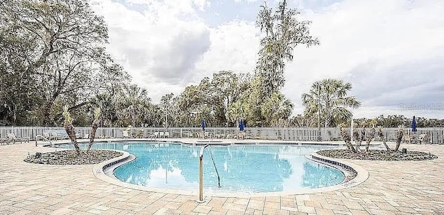 community pool featuring a patio area and fence