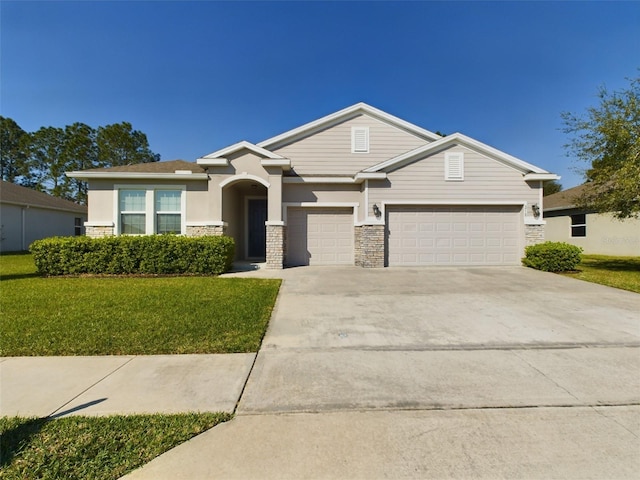 view of front facade with driveway, stone siding, an attached garage, a front lawn, and stucco siding