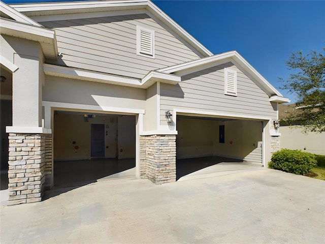 exterior space featuring stone siding and concrete driveway