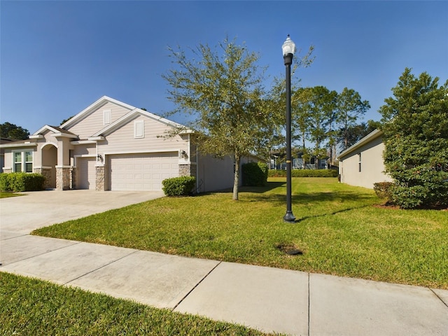 view of front of house featuring stone siding, a front yard, concrete driveway, and an attached garage