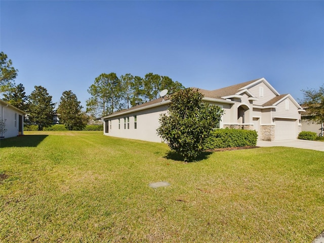 view of side of property featuring driveway, stone siding, and a yard