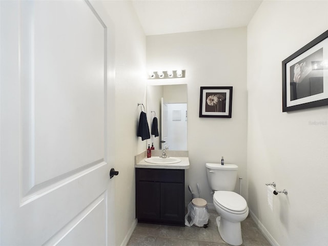 half bathroom with toilet, baseboards, and vanity